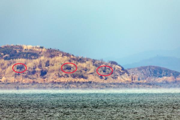 This photo shows the entrances of artillery positions (in red circles) being opened on North Korea's Jangjae Island on Nov. 29, days after the North's threat to immediately reinstate all military measures previously suspended under a 2018 inter-Korean military agreement aimed at mitigating military tensions. (Yonhap)